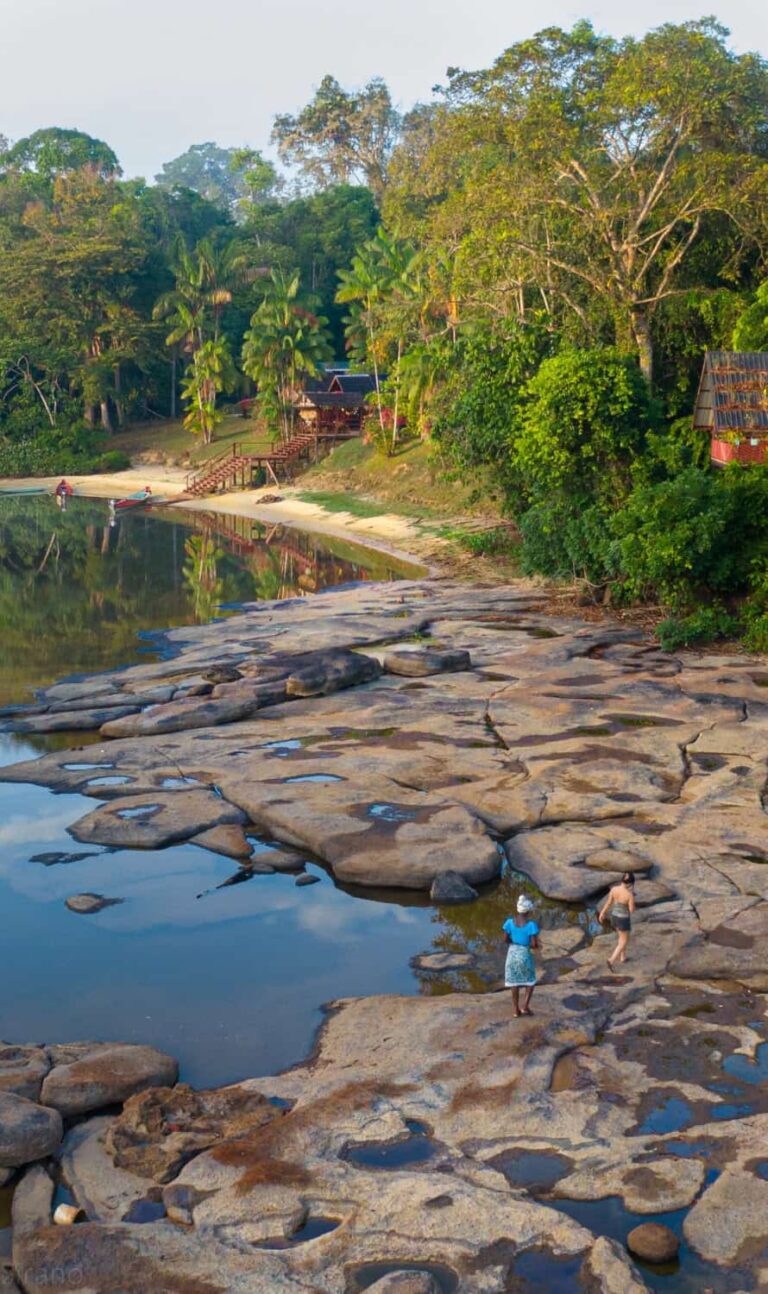 Rotsplaten en zandstrand bij Danpaati River Lodge aan de Boven-Suriname in de ochtend